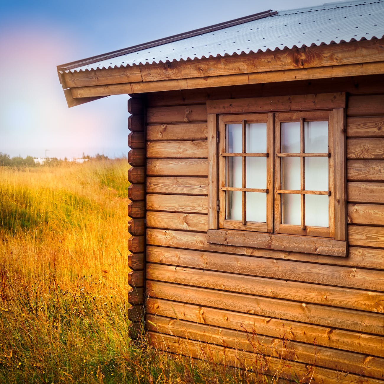 brown wooden cottage at the field during day