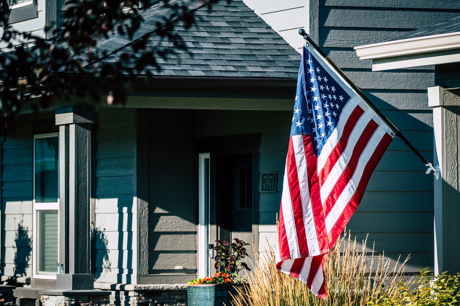 american flag waving outside a house